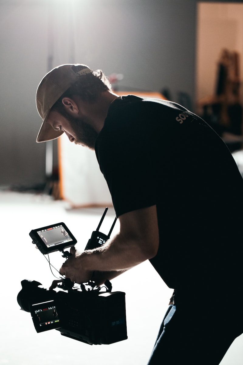 Revolt Studios man in black t-shirt holding black digital camera